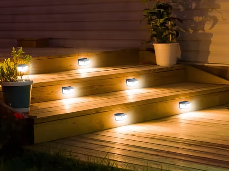 Solar-powered outdoor lights on wooden steps with Aocitek branding.